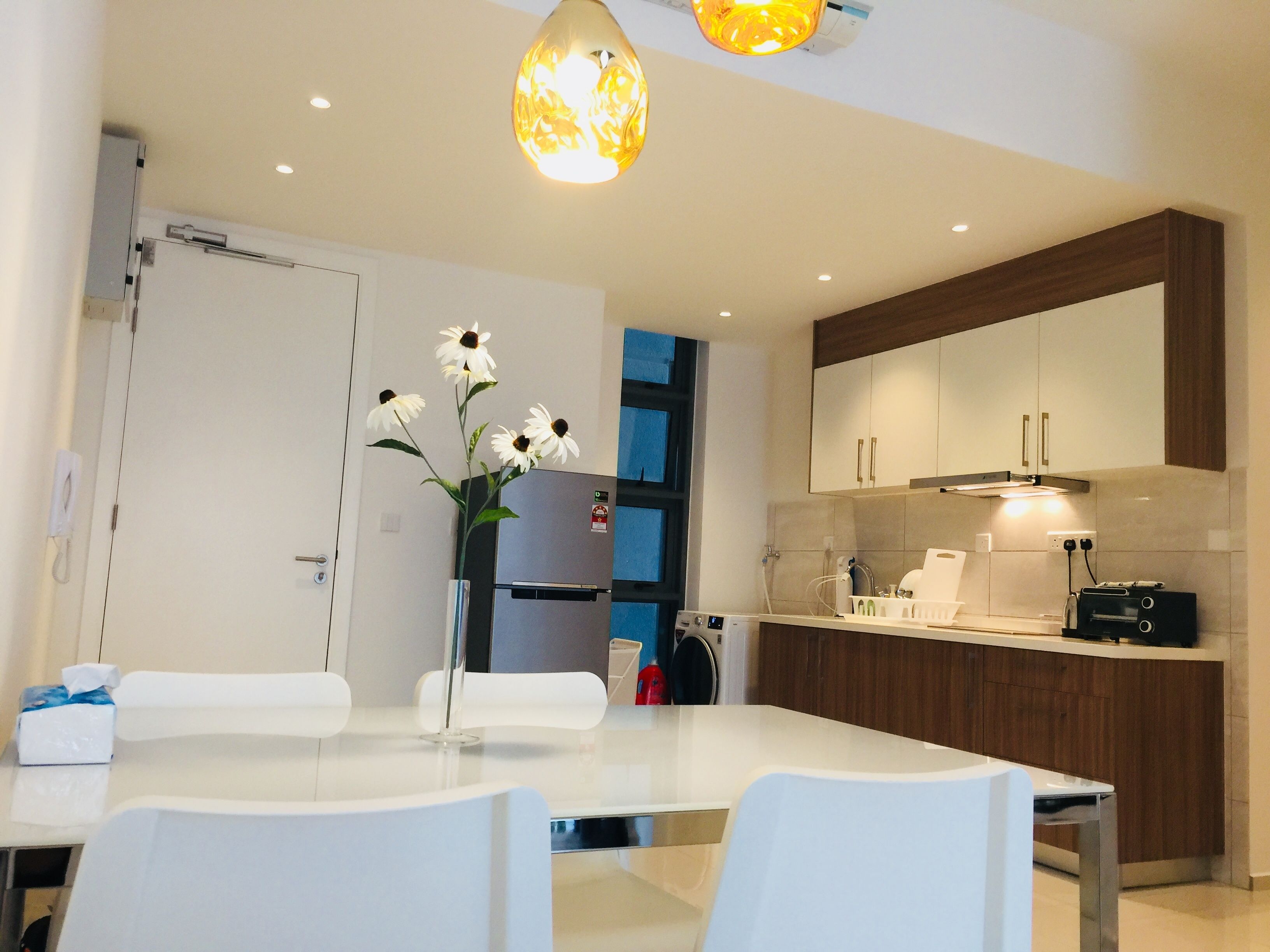 Een moderne keuken met een wit aanrecht, een inbouwoven en een houten kast.