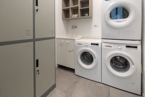 Une buanderie équipée de deux machines à laver Bosch, d’un évier et d’un meuble de rangement.