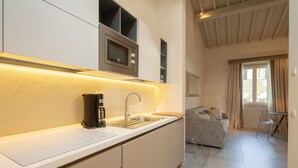 Eine moderne Küche mit Einbau-Mikrowelle, Kaffeemaschine und Spüle.
