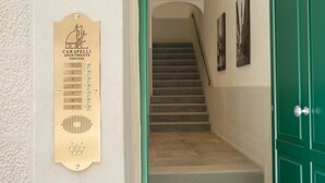 Eine Treppe, die zu einer oberen Etage führt, eine an der Wand befestigte Schlüsselkarte und eine grüne Tür.