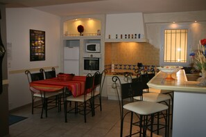 Enjoy meals in this kitchen with a dining table for four, microwave, oven, and range, plus a view of the outside.