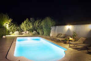 Relax by the pool surrounded by lush greenery and comfortable lounge seating.