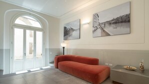 Un intérieur moderne avec un canapé, un comptoir d’accueil et deux tableaux encadrés au mur.