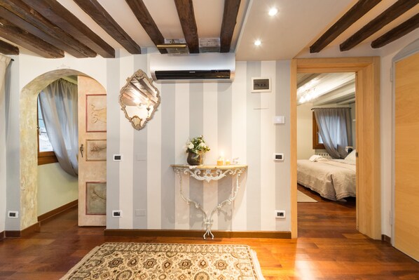Traditional hotel room with a wooden ceiling, large mirror, and patterned rug.
