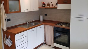 A modern kitchen with white cabinets, a wooden countertop, a gas stove, and a built-in oven. - Lake Iseo in Esmate:The House of Fairies CIR.016200CNI00013 CIN IT016200C2UAHS6HFE (Solto Collina)