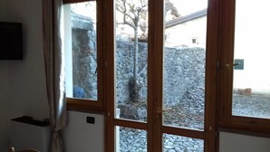 A wooden door with glass panels, a stone wall, and a small window. - Lake Iseo in Esmate:The House of Fairies CIR.016200CNI00013 CIN IT016200C2UAHS6HFE (Solto Collina)