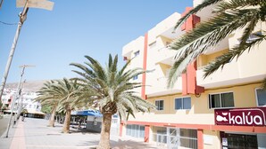 Un bâtiment avec une enseigne indiquant « Kalúa » et des palmiers devant.