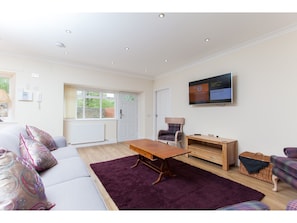 Relax in this stylish living room with a large flat-screen TV, comfortable sofa, and a cozy coffee table.