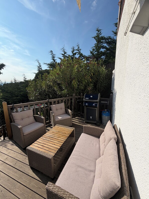 An outdoor deck with wicker furniture, a grill, and a water heater. - Luxury, self contained, airconditioned studio with private terrace & use of pool (Begur)