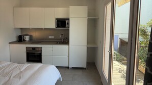 A compact kitchen with white cabinets, a microwave, and a sink. - Luxury, self contained, airconditioned studio with private terrace & use of pool (Begur)