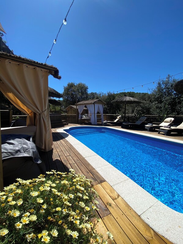 A swimming pool with a wooden deck, a covered seating area, and a small pavilion. - Luxury, self contained, airconditioned studio with private terrace & use of pool (Begur)