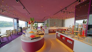 Un espace repas moderne doté d’un îlot central, d’un buffet et d’un aménagement pour s’asseoir.