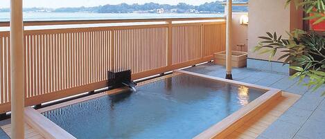 A hot spring area with a wooden deck and a view of the water.