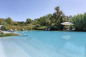 A clear swimming pool with lounge chairs and umbrellas, surrounded by lush greenery. - Villa in San Concordio Di Moriano with 6 bedrooms sleeps 12 (Lucca)