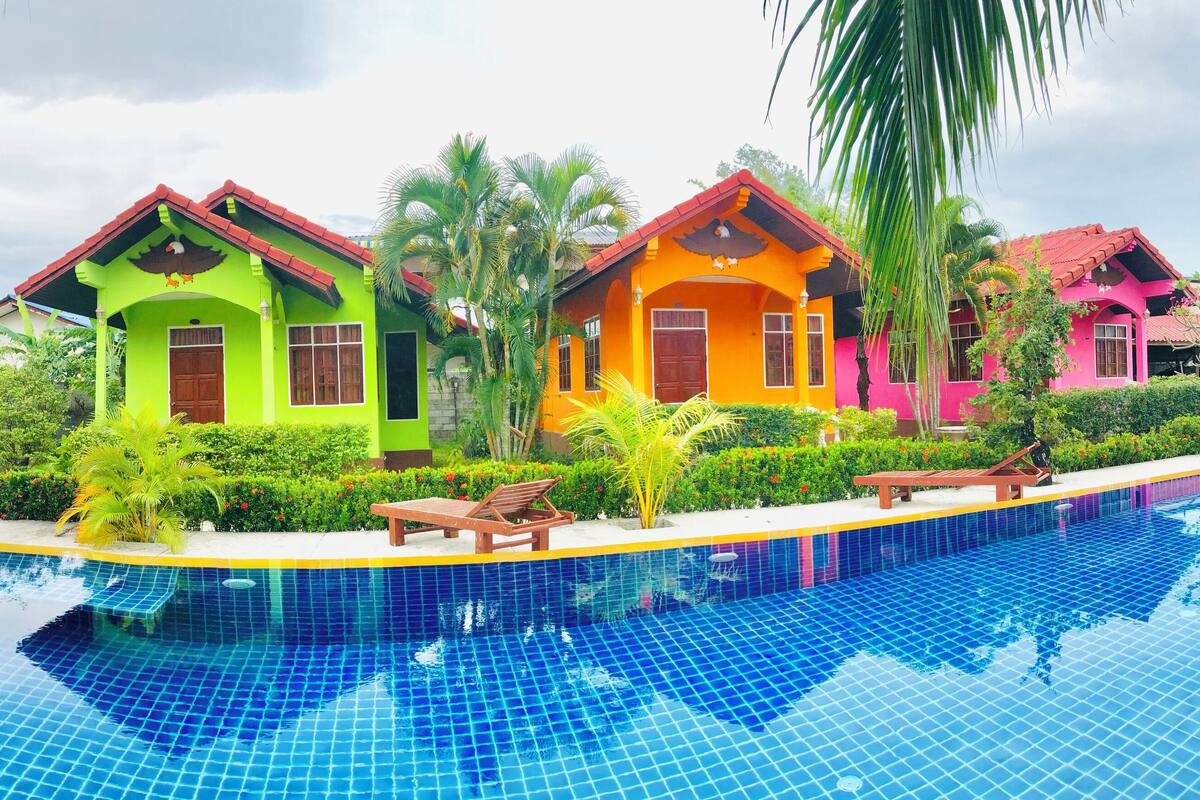 A swimming pool with colorful houses in the background.