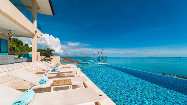 A poolside area with lounge chairs and a view of the ocean. - Luxury 5-bedroom villa with panoramic sea view (Koh Samui)