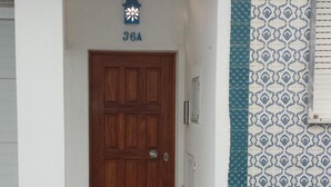 Ein Wohnhauszugang mit Holztür, Briefkasten und Hausnummer 36A.