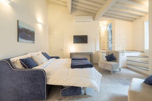 A bedroom with a bed, a chair, a desk, and a TV. - Carapelli 7 Spectacular penthouse (florence)
