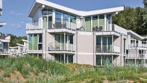 A modern multi-story residential building with balconies, large windows, and a flat roof. - Dünenvilla 12, Whg 2 (Travemünde Waterfront)