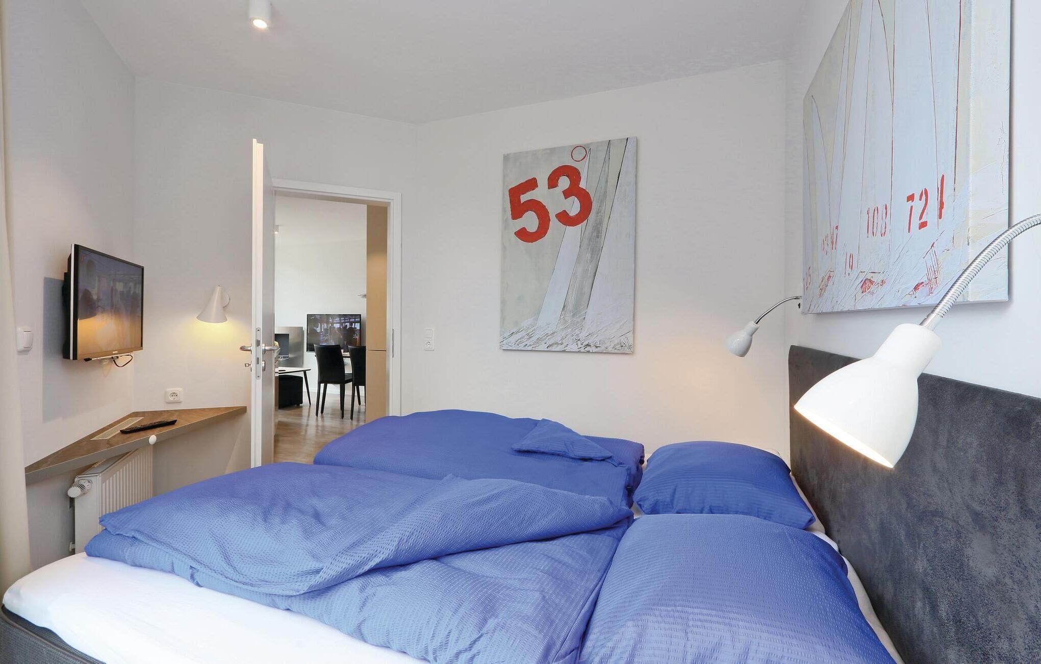 Une chambre d’hôtel avec un lit, un bureau équipé d’un ordinateur et une t élévision.
