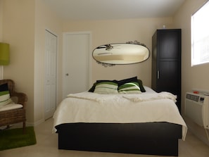 A bedroom with a bed, a chair, a wardrobe, a mirror, and a radiator. - Sun, beach, and great deals—discover big discounts! (Cape Coral)