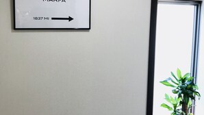 A wall with a sign reading "PRADA MARFA 1837 MI" and an arrow pointing right. - ONE Hostel&Standing Bar (Himeji)