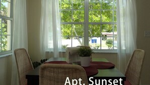 A room with a table, chairs, and a view of greenery outside. - Sun, beach, and great deals: Huge discounts on vacation destinations! (Cape Coral)