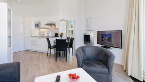 Un appartement moderne comprenant une cuisine, un coin repas et un salon.