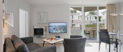 A modern living room with a sofa, a flat-screen TV, and a fireplace.