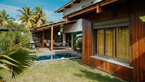 Une maison moderne dotée d’une piscine, d’une façade en bois et d’un espace patio.