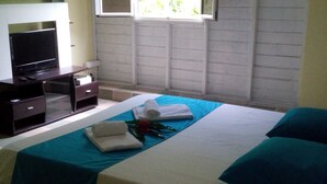 Una habitación de hotel con cama, televisión y ventana.