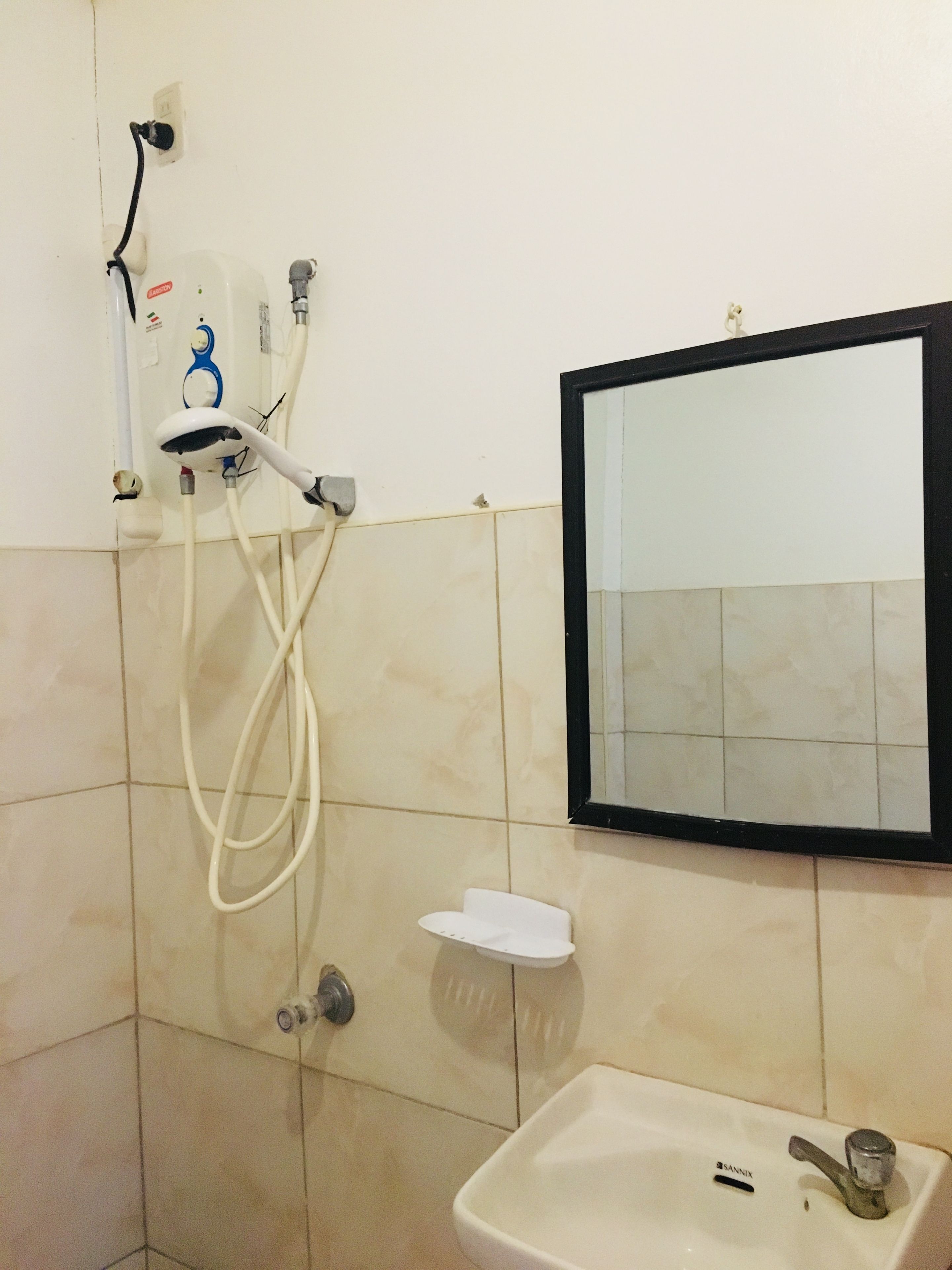 A bathroom with a shower, a sink, and a mirror.