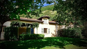 A house with a tiled roof, a small balcony, and a garden. - Gites le Paradis *** Superb view of Vercors (Pont-en-Royans)