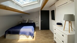 A bedroom with a skylight, a bed, a dresser, and a door. - Haven of peace in the vineyards (Violes)