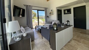A modern living room with a sofa, a coffee table, and a TV mounted on the wall. - Haven of peace in the vineyards (Violes)