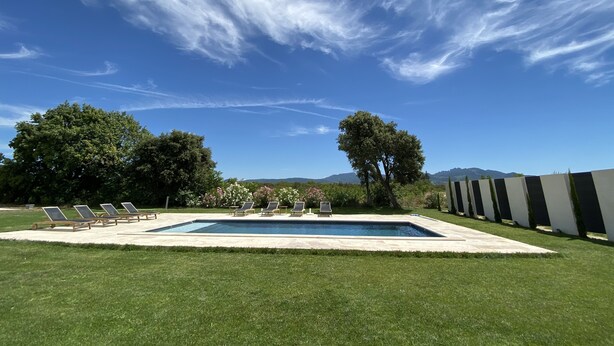 A swimming pool with lounge chairs, surrounded by well-maintained grass and trees, with mountains in the background. - Haven of peace in the vineyards (Violes)