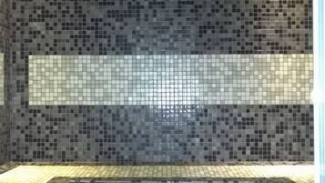 Bathroom features a tiled floor and walls with a decorative pattern.