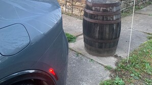 A car parked on a residential street with a stone wall, a wooden barrel, and a stop sign. - Right in the Quaint Village of Hammondsport (Hammondsport)