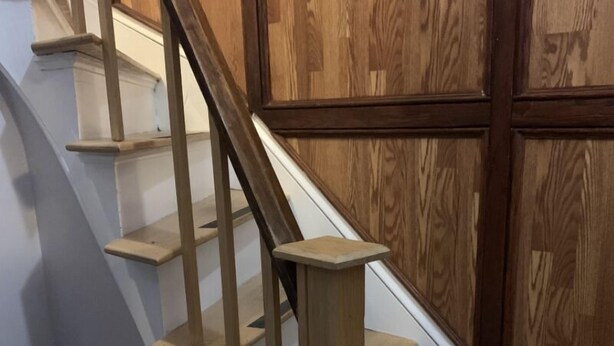A wooden staircase with a handrail, leading to a landing with a small round table and chairs. - Right in the Quaint Village of Hammondsport (Hammondsport)