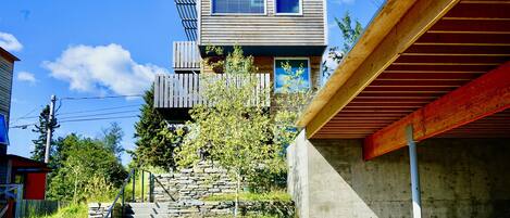 A modern two-story house with a stone staircase leading to the entrance.