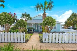 A two-story house with a front porch, white picket fence, and a sign indicating 'The Crow's Nest Destin Palms'. - Updated Home-Priv Hot Tub-Comm Pool-Close 2 Beach (Destin)
