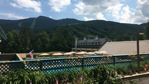 Een hotel met uitzicht op bergen, parasols en Amerikaanse vlaggen.
