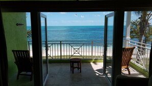 A balcony with a view of the ocean, a chair, and a small table. - Amazing Old Bahama Bay condo perfect for you! (West End Bahamas)
