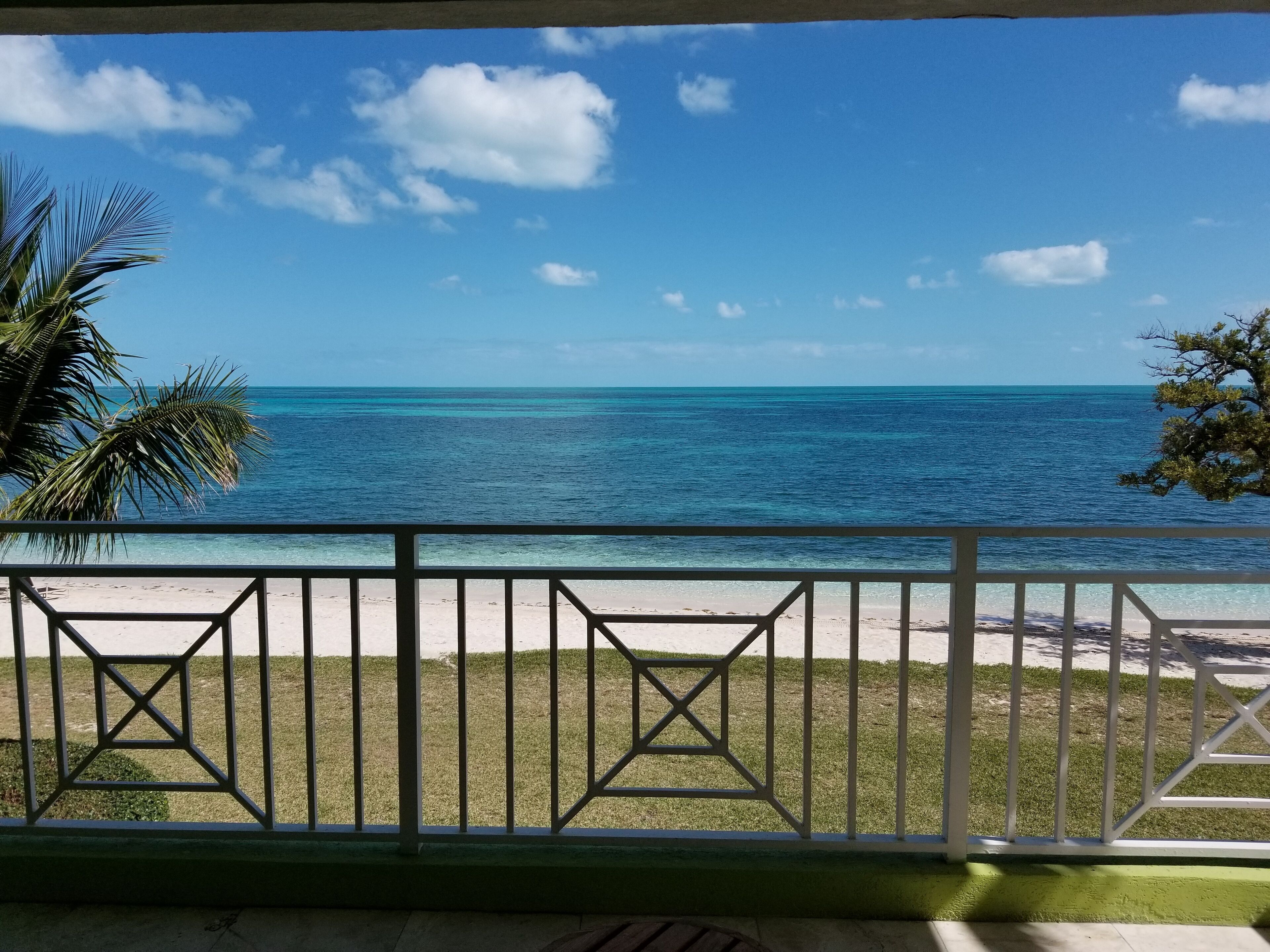 A balcony with a view of a beach and ocean.