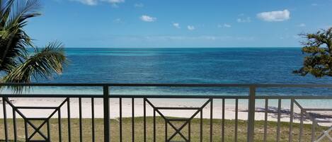 A balcony with a view of a beach and ocean.