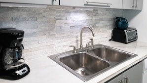 A kitchen with a double sink, a coffee maker, and a toaster. - GORGEOUS 2BD/2 BATH ON THE BEACH! DESIGNER APT.LUX! BEST LOCATION. (Cangrejo Arriba)