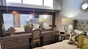 A hotel room with a bed, a desk, a chair, a mirror, and a lamp. - GORGEOUS 2BD/2 BATH ON THE BEACH! DESIGNER APT.LUX! BEST LOCATION. (Cangrejo Arriba)