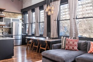 A modern kitchen with a central island, stainless steel appliances, and a dining area with a table and chairs.