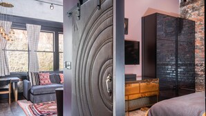 Une chambre à coucher moderne comprenant un lit, une commode et un coin salon avec un canapé et une table.