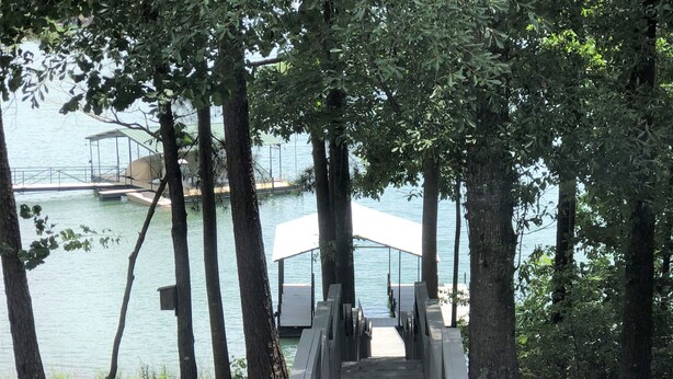 A wooden boardwalk leading to a covered area by the water, surrounded by trees. - Bannister Cottage – Lakefront Getaway w/ Dock, Porch & Views, 20 mins to Clemson (Anderson)